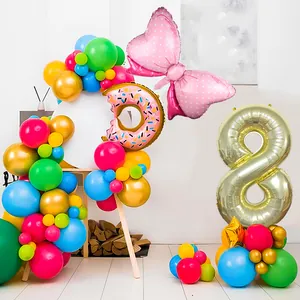 Macro shot of 8th birthday party balloon set with golden number and donut foil shapes