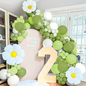 Dettaglio dell'arco di palloncini verde salvia con grandi margherite per decoro di feste