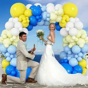 Arco di palloncini macaron blu e gialli per una cerimonia di matrimonio all'aperto in spiaggia