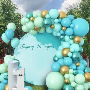 Mint green and gold balloon arch kit with blue birthday backdrop for outdoor party decor