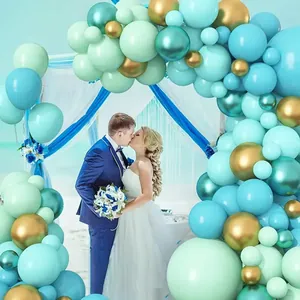 Detail of mint green and metallic gold balloon arch set for beach wedding decor