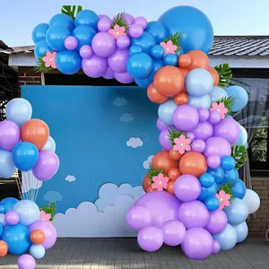Blue and purple balloon arch kit with floral accents and palm leaves for party decor