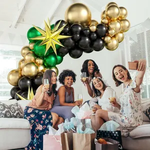 Close-up of gold starburst balloon with dark green and gold party balloon arch decor