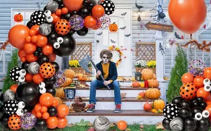 Halloween balloon arch kit with orange and black balloons on a decorated porch