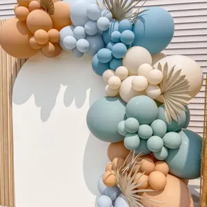 Detailed view of bohemian macaron balloon arch with dried palm leaves for party decor