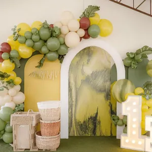 Jungle theme balloon arch with olive green and yellow latex balloons and palm leaves