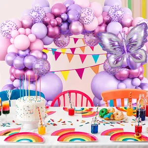 Detailed close-up of purple butterfly balloon arch with rainbow party tableware and decorations