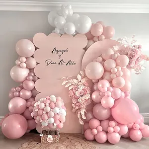 Arco di palloncini rosa con fondali personalizzati e fiori per eventi di festa del bambino