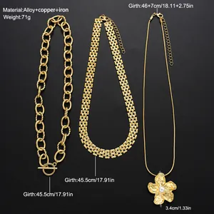 Detalle de tres collares dorados con colgante de flor con perla y una cadena de eslabones