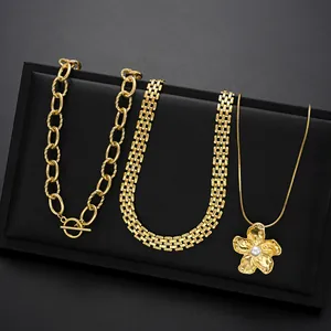 Set de tres collares dorados con cierre OT, cadena tejida y colgante de flor y perla