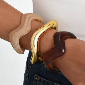 Three-piece stackable wavy bangles in gold, marble, and tortoise shell resin style