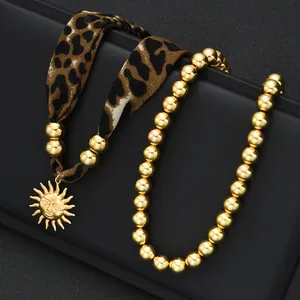 Détail du collier en tissu léopard avec pendentif soleil doré et ensemble de perles