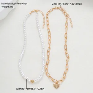 Detalle de set de collares de perlas y cadena dorada con colgante de corazón y medidas