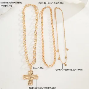 Detalle de un juego de 3 collares dorados con colgante de cruz y lentejuelas redondas