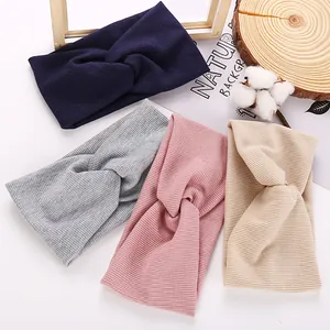 Flat lay of four textured ribbed knit twisted headbands in navy, grey, pink, and cream