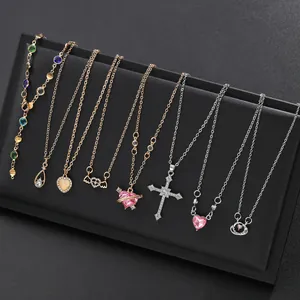 Juego de ocho collares elegantes con colgantes de corazón, cruz y gemas en panel negro