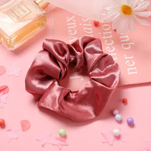 Détail d'un chouchou en satin rose avec texture soyeuse et plis élégants