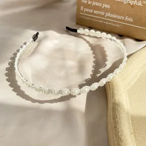 Gedetailleerde close-up van een witte parelhoofdband met zijde en metalen basis