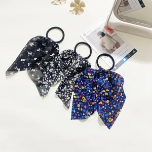 Detailed view of floral bow hair ties in three patterns on a vintage aesthetic background