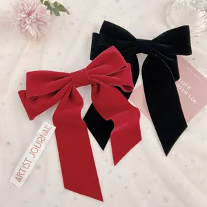 Detail view of red and black velvet bow hair clips on a romantic mesh background