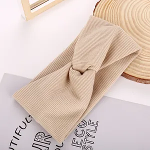 Macro shot of khaki ribbed knitted wide headband with elegant criss-cross knot design