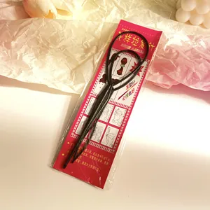 Detail of large and small hair loop styling tools in black on tutorial packaging card