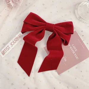Elegant deep red velvet bow hair clip with long ribbons in a vintage aesthetic