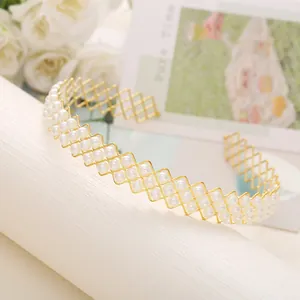 Détail du serre-tête ondulé doré avec trois rangées de perles blanches élégantes
