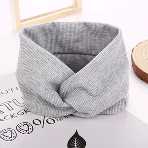 Grey knitted twist headband with ribbed texture for women in a retro chic winter style