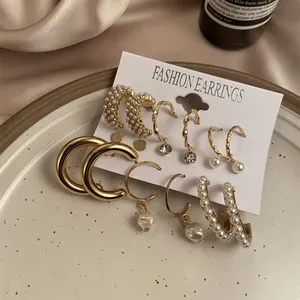 Detailed close-up of gold earring set with white pearls and rhinestones on display