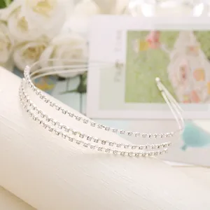 Détail d'un serre-tête argenté à trois rangées avec des strass blancs brillants pour mariages