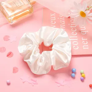 Chouchou en satin blanc uni pour femmes avec texture de soie lisse sur fond rose doux