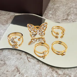 Dettaglio di un set di cinque anelli a farfalla dorati con strass su uno specchio