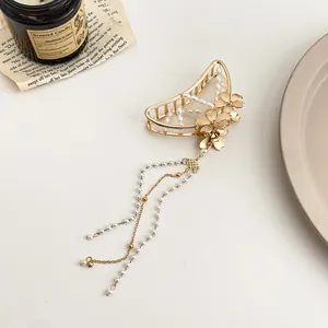 Détail du clip à cheveux fleur en métal doré avec d'élégantes franges de perles