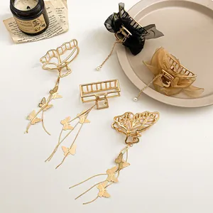 Pinces à cheveux papillon dorées avec pompons et perles sur fond style vintage