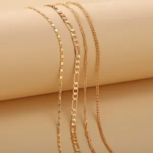 Juego de tres tobilleras doradas con cadena de serpiente y espiga sobre fondo beige