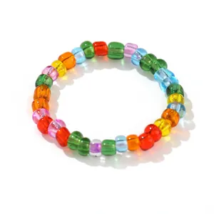 Handgemaakte ring van kleurrijke glazen kralen met elastische band in regenboogkleuren
