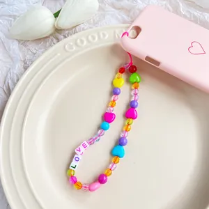 Dettaglio del ciondolo per telefono arcobaleno con perline LOVE e cuori colorati