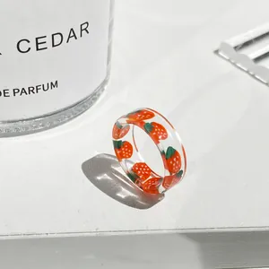 Dettaglio anello in resina trasparente con motivi a fragola e finitura lucida