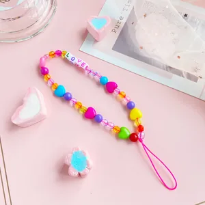 Colorful beaded phone strap with LOVE letter charms and hearts on a pink background