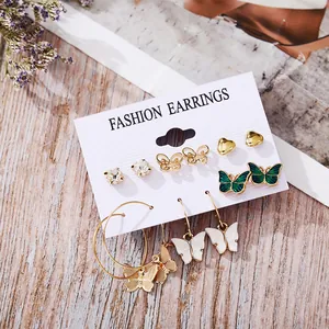 Set of 6 gold earrings with acrylic butterfly, heart, and zircon details on display card