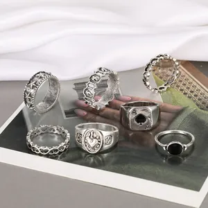 Macro shot of 6-piece vintage silver heart and ace of spades rings on white silk
