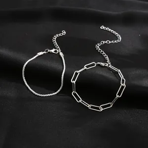 Dettaglio della catena scintillante e del bracciale a graffetta argento su raso nero
