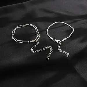 Set di bracciali in argento con maglia a graffetta e trama su sfondo di raso nero elegante