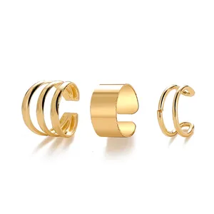 Three-piece gold ear cuff set with layered, polished, and wire designs for non-pierced ears