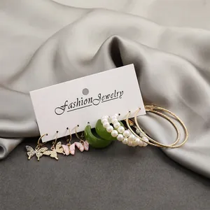 Close-up of 6-piece earring set featuring gold butterflies, pearls and resin hoops