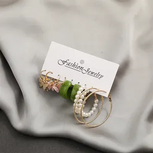 Detailed set of six retro earrings including gold hoops, pearls, and acrylic butterflies