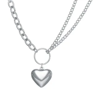 Detail of silver asymmetric dual chain necklace with a puffy heart metal pendant