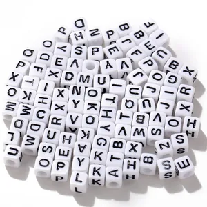Détail macro de perles cubes blanches en acrylique avec lettres noires pour bijoux DIY