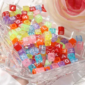 Vue rapprochée de perles alphabet colorées dans un bol en verre pour la création de bijoux DIY